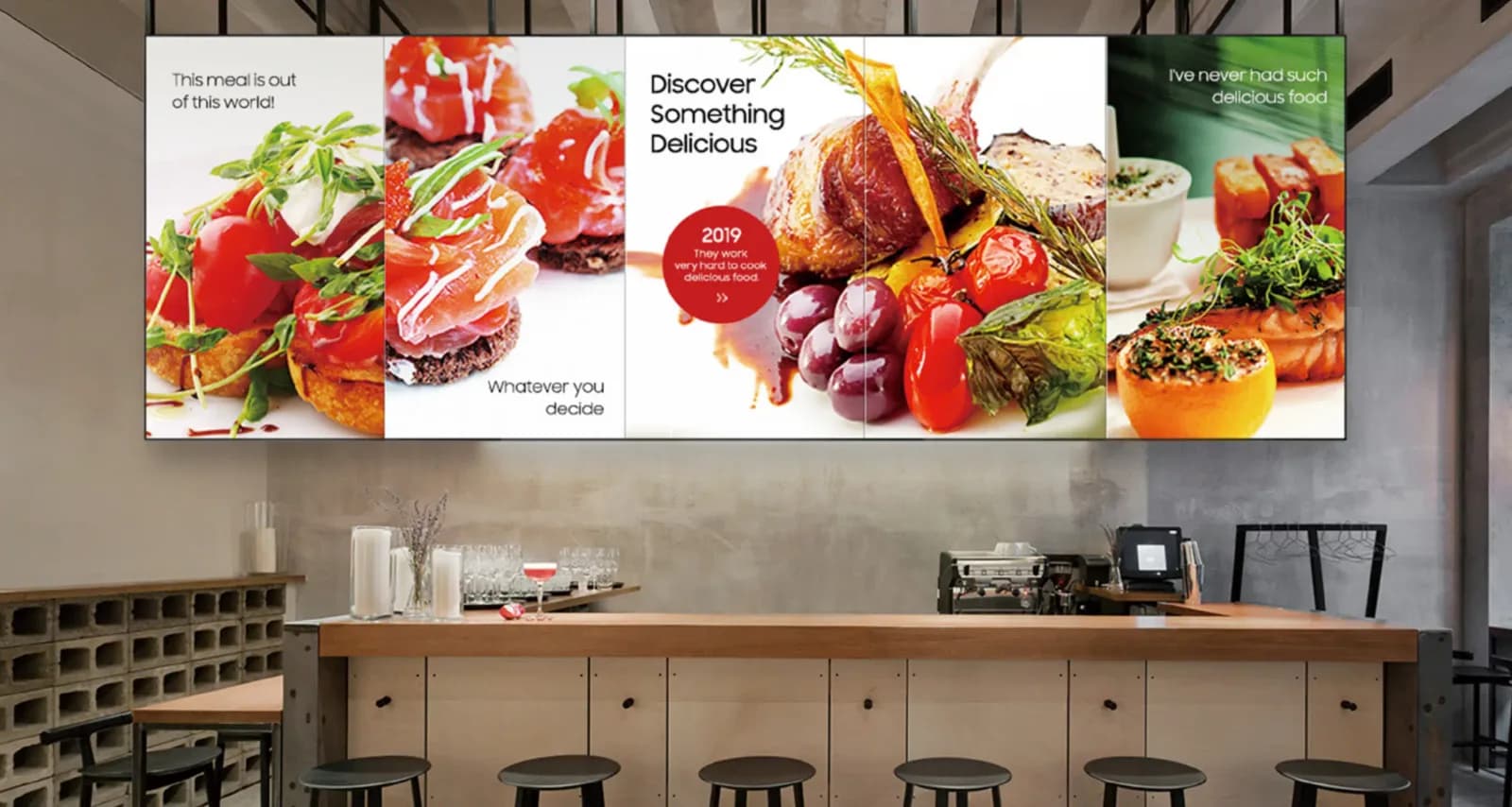 Un mur vidéo de plats au-dessus du comptoir d'un restaurant
